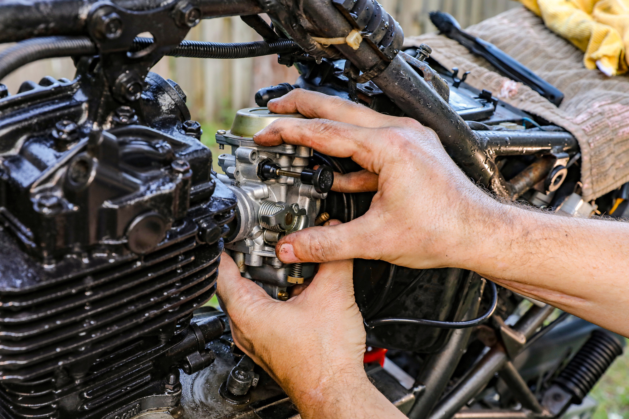 Close-Up Shot of a Person Fixing an Engine of a Motorcycle